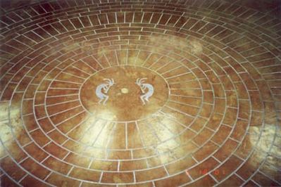 Image of circular brick pattern cut in acid stained concrete floor.
